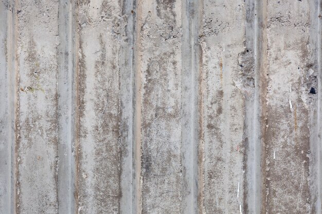 Vecchia superficie graffiata grigia del muro di cemento con linee verticali e consistenza ruvida