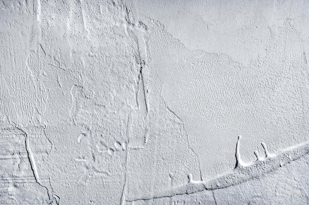 Старая серая стена с неравномерно нанесенной шпаклевкой Интересная фактура старой стены Неровные мазки шпаклевки на стене