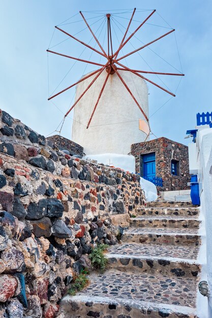 Old greek windmill on santorini island in oia town with stairs in street santorini greece