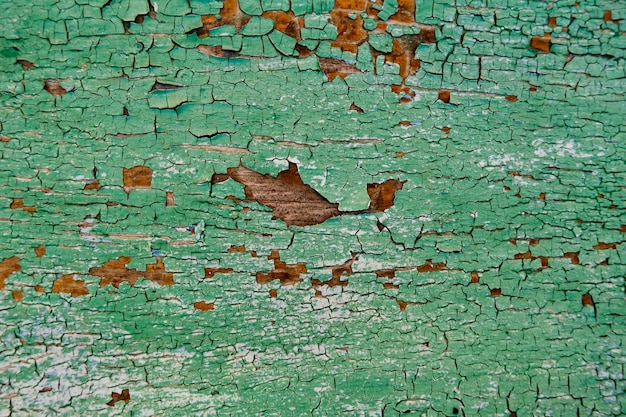 古い緑のひびの入った壁の背景