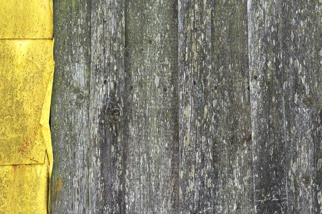 old grey wooden background with yellow metal part