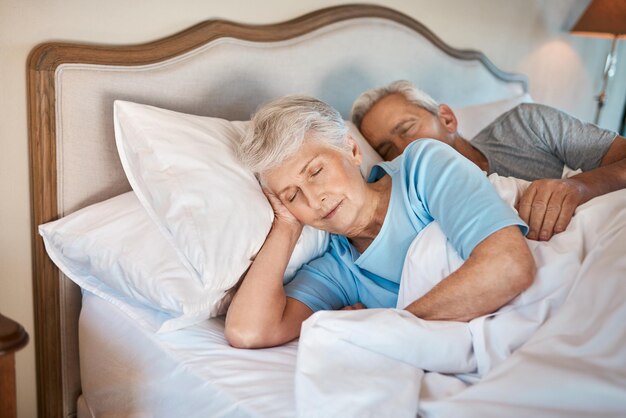 Photo old habits never die cropped shot of an affectionate senior couple cuddling each other while asleep in bed at a nursing home