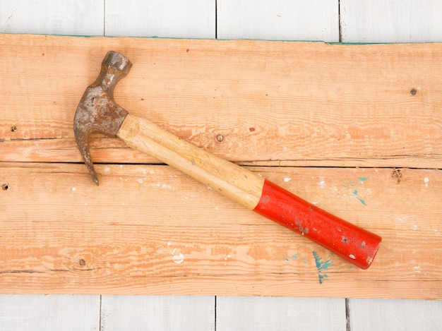 Old hammer on wooden background