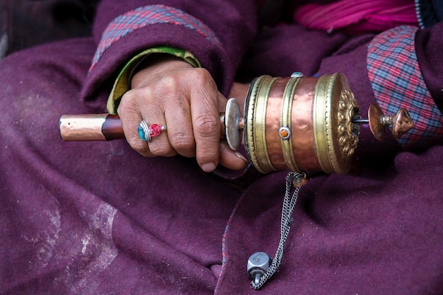 Old hands of a Tibetan woman holding prayer buddhist wheel at a Hemis monastery Leh district Ladakh Jammu and Kashmir north India Close up