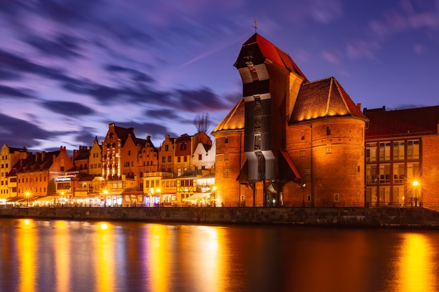 Old harbour crane and city gate Zuraw in old town of Gdansk at night, Poland