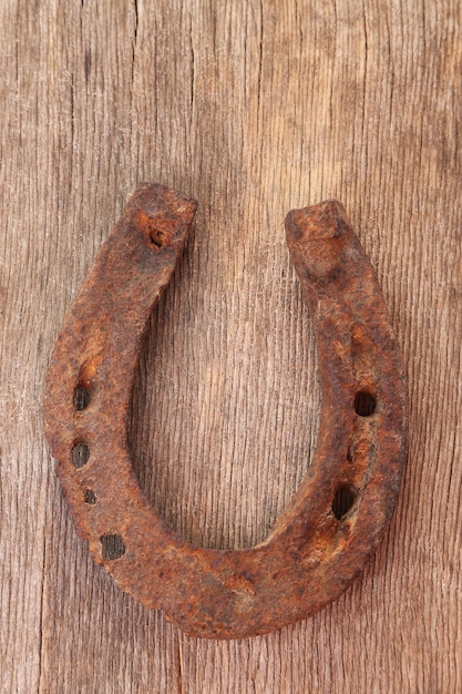 Photo old horse shoe on wooden background