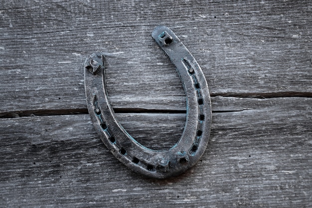 Foto vecchio ferro di cavallo su una vecchia tavola di legno