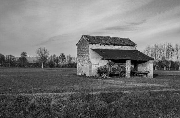 Old house on field against sky