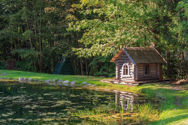 写真 ポンド近くの森の中の古い家