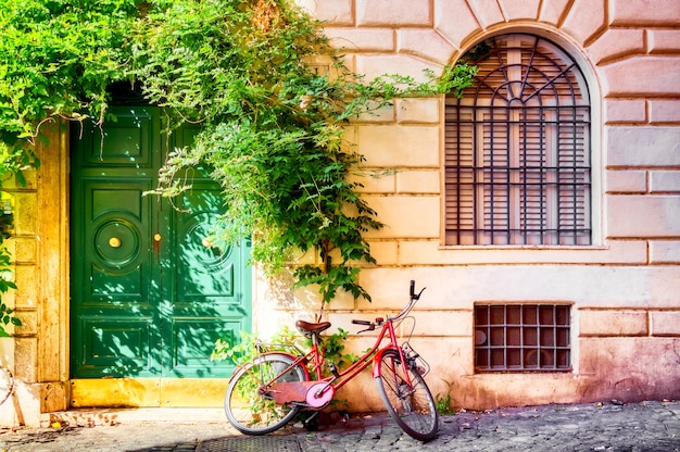 Vecchio muro di casa a roma con la bicicletta