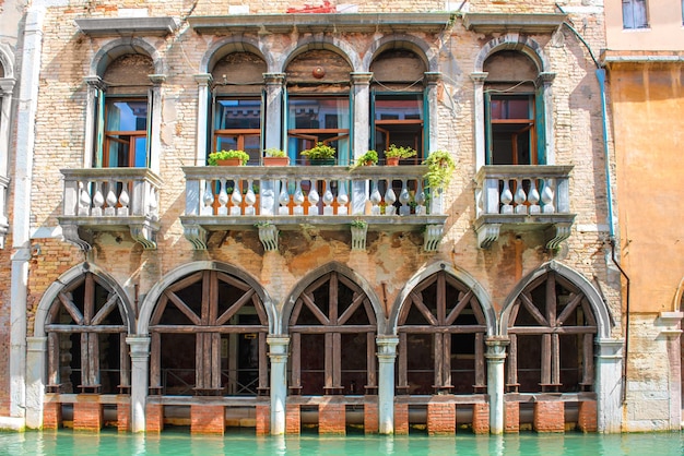 Old house with arches and balcony near canal in Venice