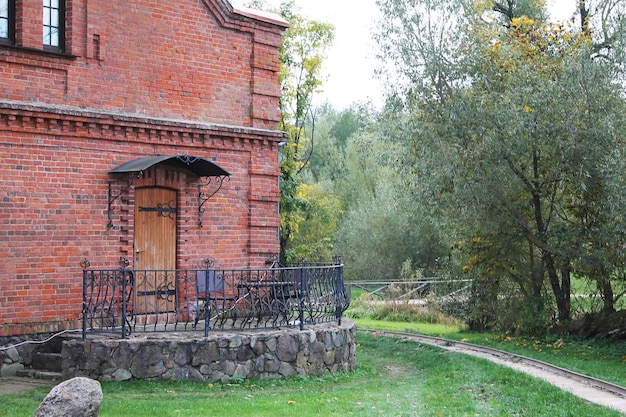 An old house with a beautiful door against the backdrop of an autumn forest