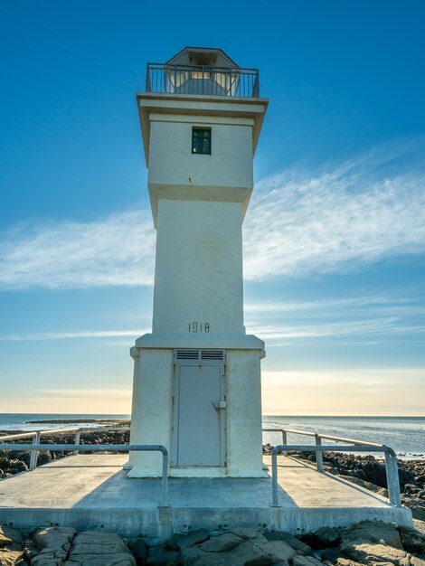 The old inactive arkranes lighthouse at end of peninsula was built since 1918 under blue sky iceland