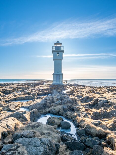 The old inactive Arkranes lighthouse at end of peninsula was built since 1918 under blue sky Iceland