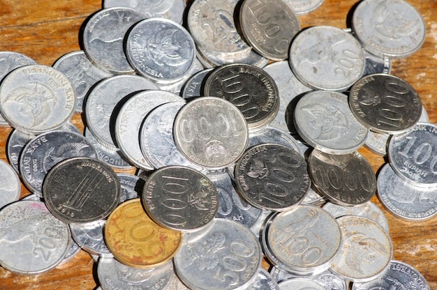 Old Indonesian money rupiah coins on vintage wooden background