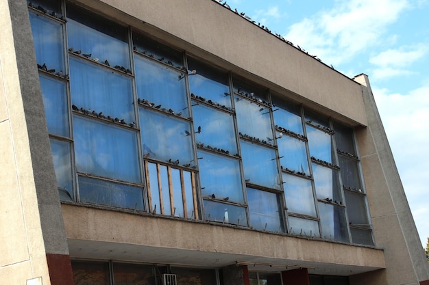 Old industrial building facade with doves and blue sky