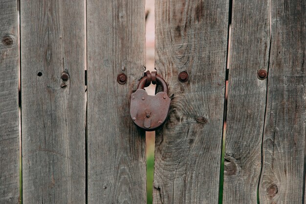 An old iron lock on a wooden gate, a rustic barn.