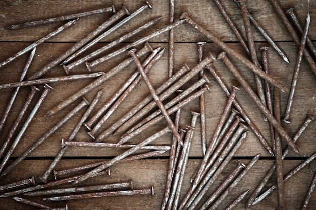 Old iron nails on a wood background