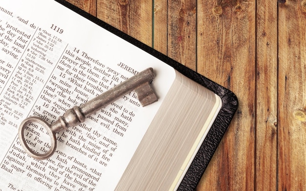 an old key on top of an old Bible