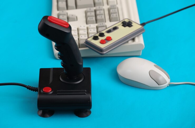 Photo old keyboard, joystick, gamepad and mouse on blue background. retro gaming. 80s.