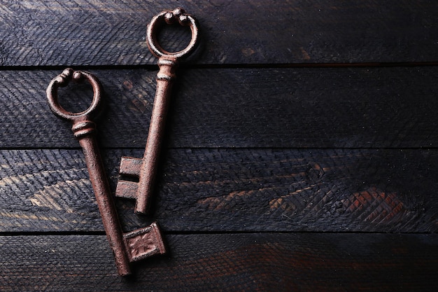 Старые ключи на темном деревянном фоне копией пространства