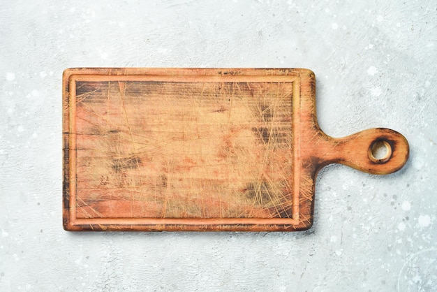 Old kitchen wooden brown board On a stone background Top view