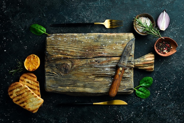 Vecchia cucina vassoio in legno su un tavolo di pietra cucinare su uno sfondo di pietra vista dall'alto