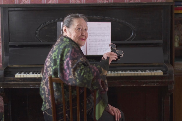 Old lady pianist seating at the piano, active ageing