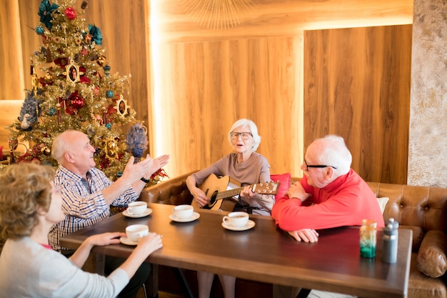老婦人が友達と歌を歌う