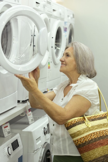 Old lady in store choosing washing machine