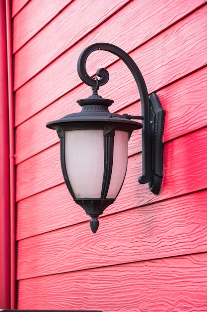 Old lamp on red wood wall