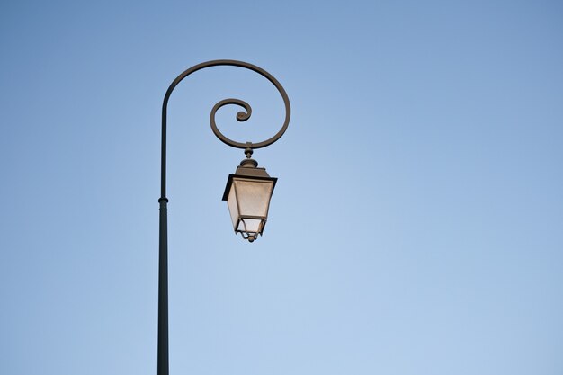 Old lamppost on the background of blue sky