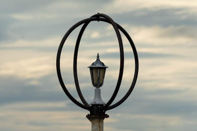 Old lantern against the beautiful cloudy sunset sky