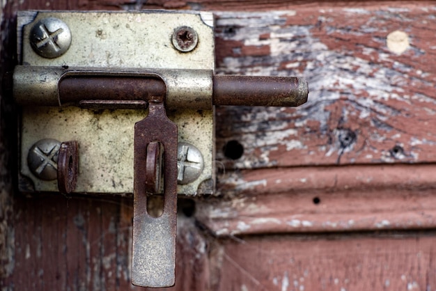 Old latch lock on a wooden door close up