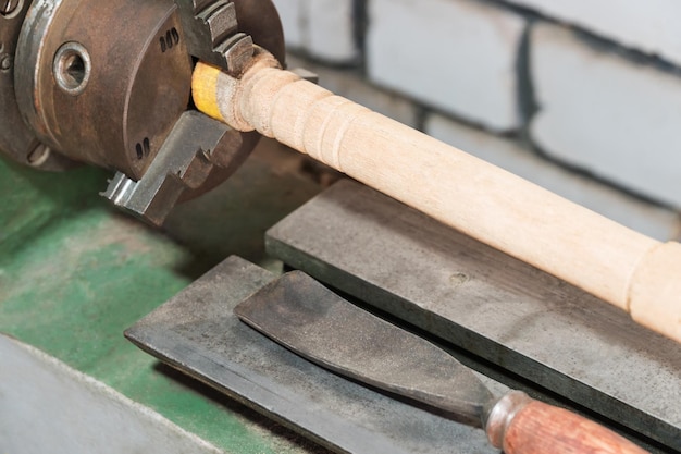 Old lathe for processing wood with a wooden bar in a collet