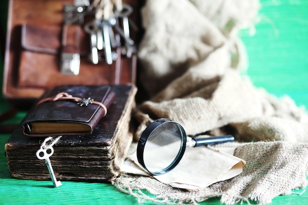 Vecchia borsa in pelle con una lente di ingrandimento su uno sfondo di tavolo in legno marrone viaggiatore con spazio per le copie.