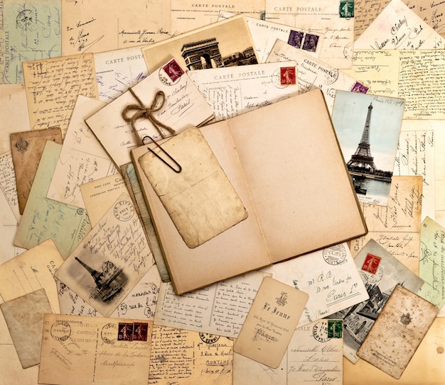 Old letters, french post cards and empty open book. nostalgic vintage background