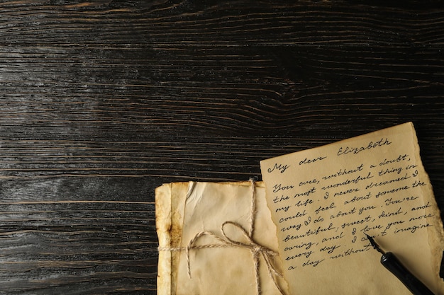 Old letters letter with text and pen on wooden background space for text