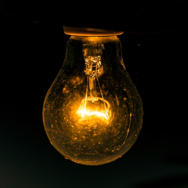 old light bulb glowing in dark close up