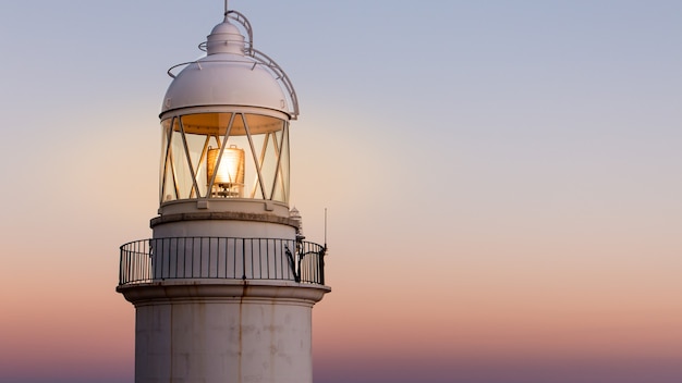 Foto vecchio faro sulla costa con un bel tramonto sullo sfondo