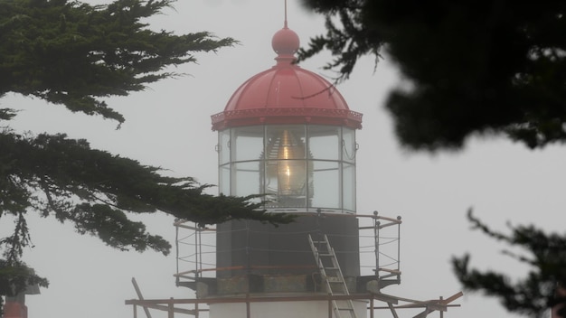Old lighthouse fresnel lens glowing foggy rainy weather illuminated beacon usa
