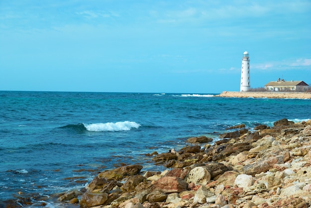 海岸の古い灯台。嵐、波、青い空。