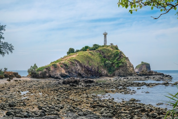 An old lighthouse on top of a cliff near a rocky shore