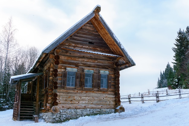 Old log Russian peasant hut izba in the winter landscape