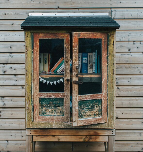 Photo old looking bookcase with books outside