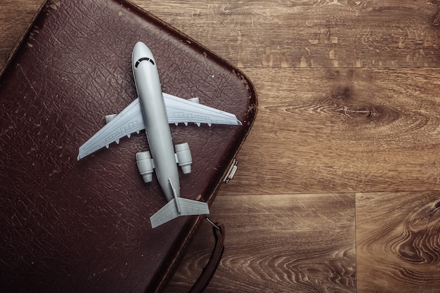 Old luggage and airplane figurine on wooden floor