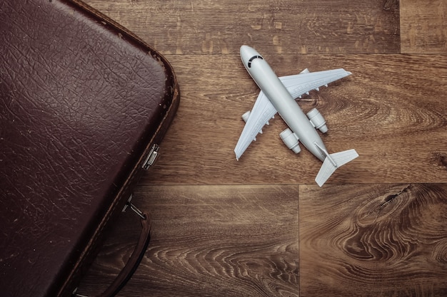 Old luggage and airplane figurine on wooden floor