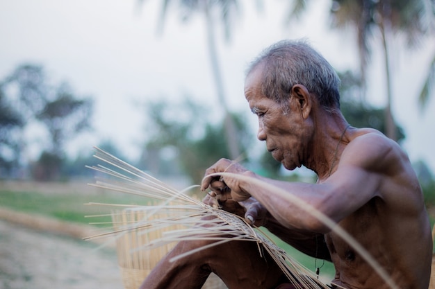 Old man are weaving bamboo wood.