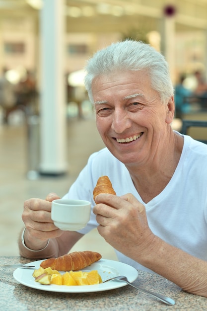 Old man at breakfast on the table