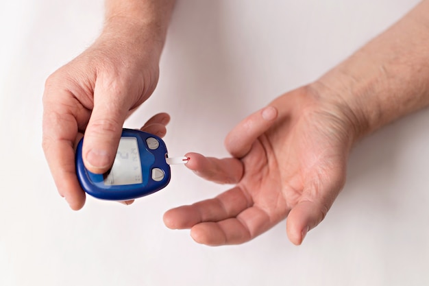 Old man checks blood sugar using a set of blood sugar tests